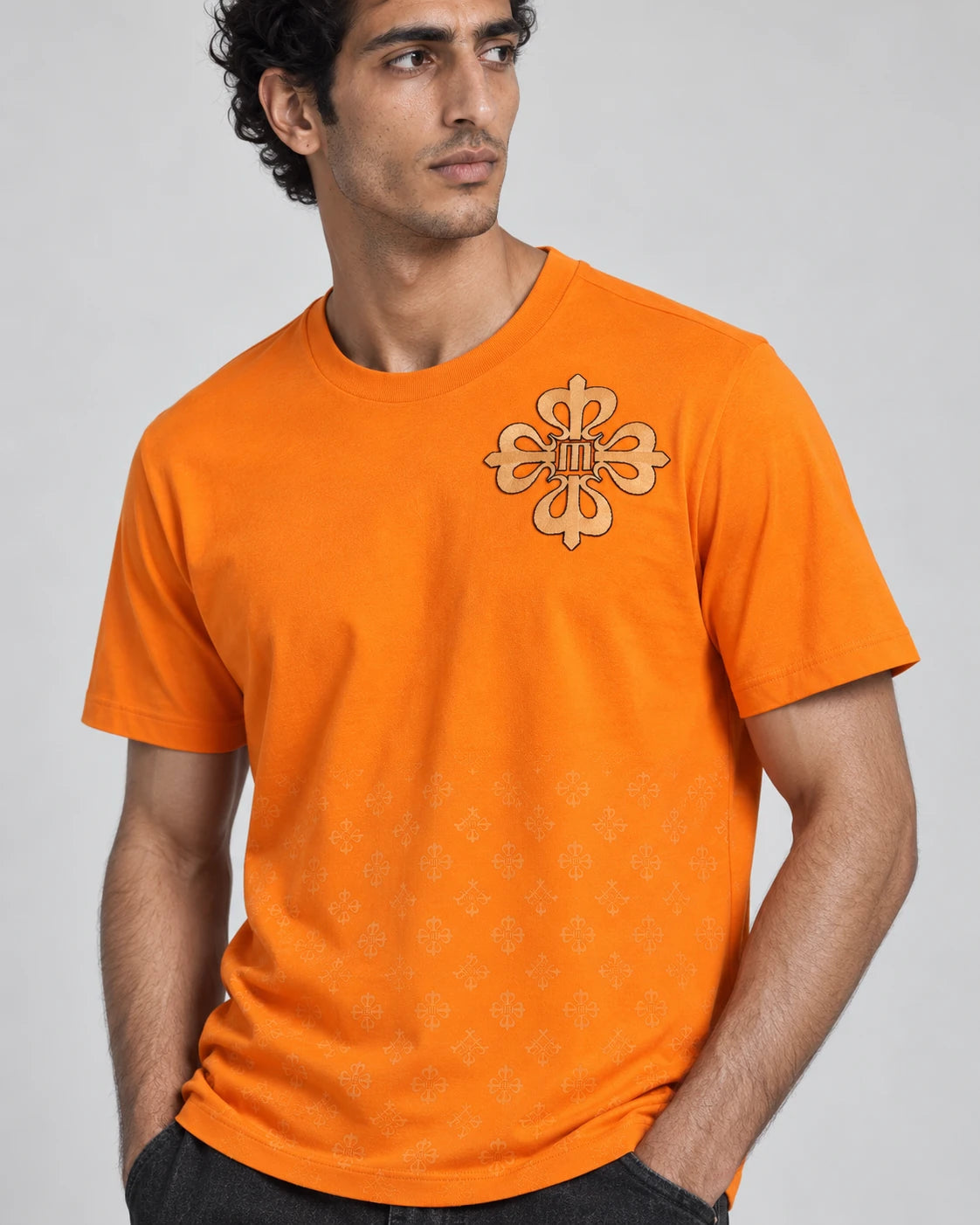 MOMANI Emblem Crest T-Shirt in Orange, worn by a model, close detail
