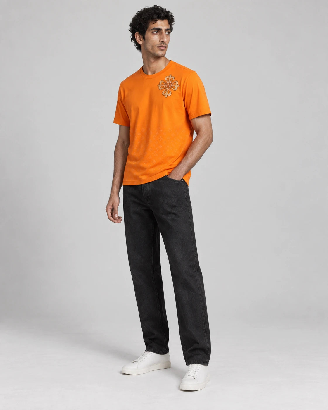 MOMANI Emblem Crest T-Shirt in Orange, worn by a model, three-quarter view