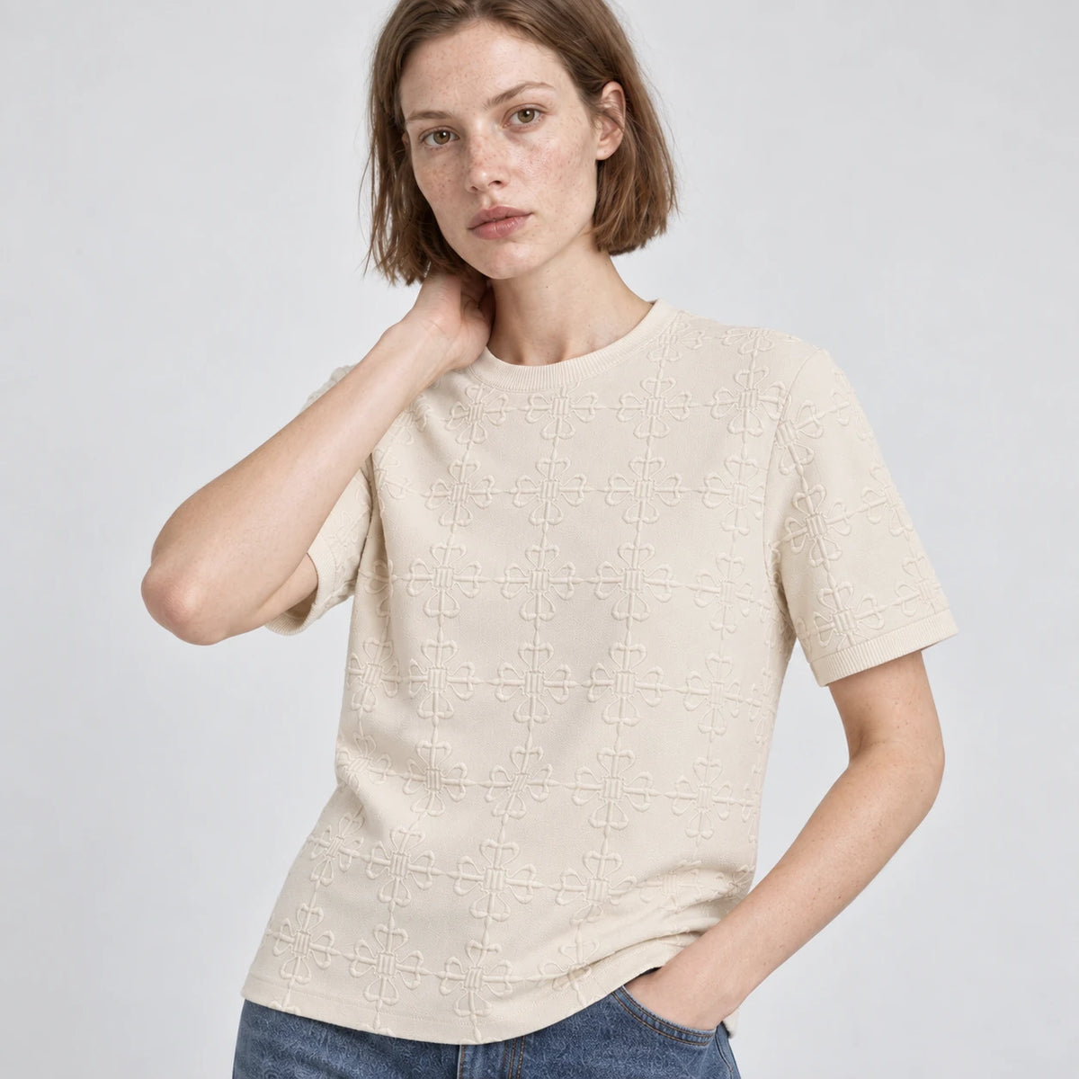 MOMANI Emblem Relief T-Shirt in Cream, worn by a model, close detail