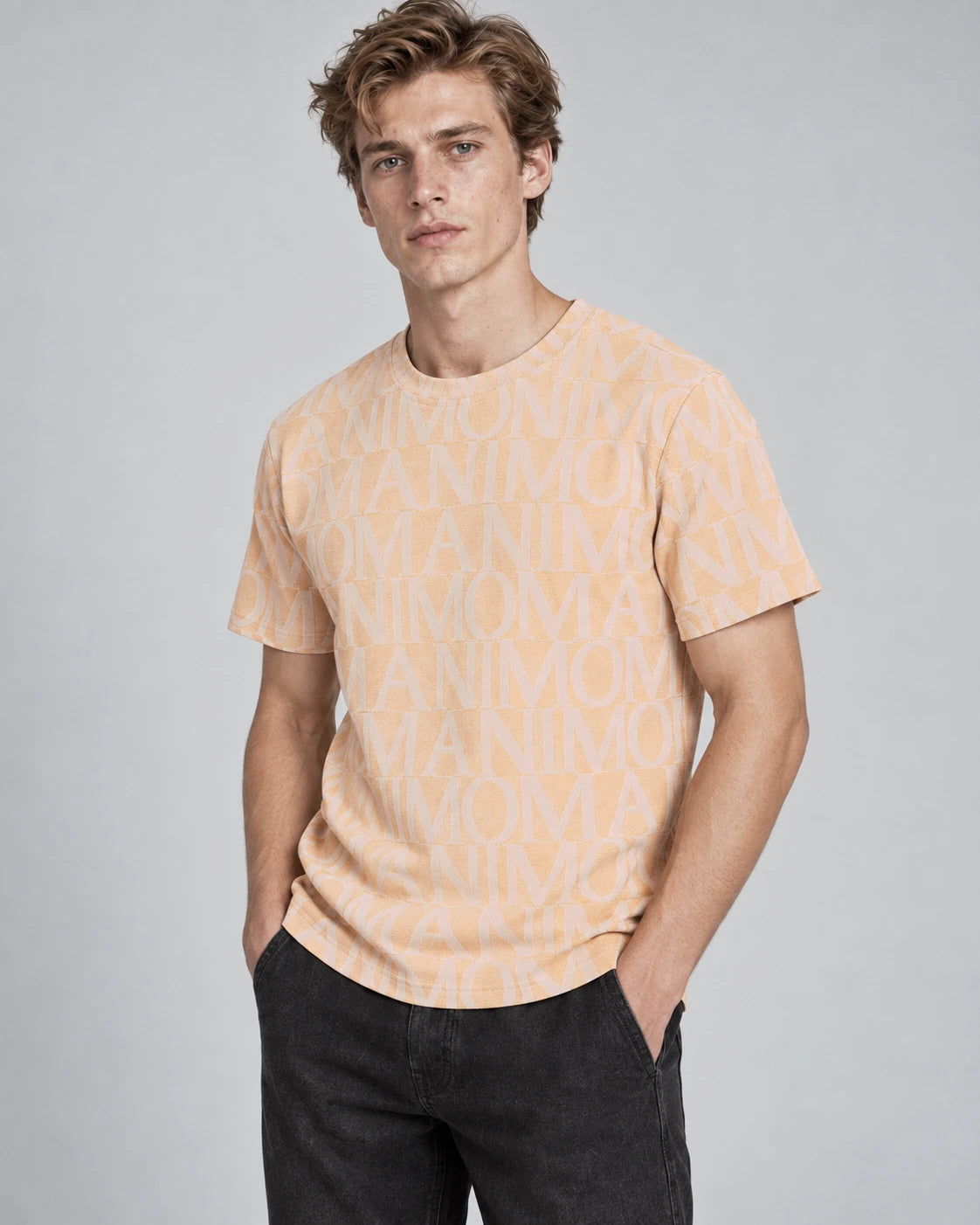 MOMANI Logotype Jacquard T-Shirt in Peach, worn by a model, close detail