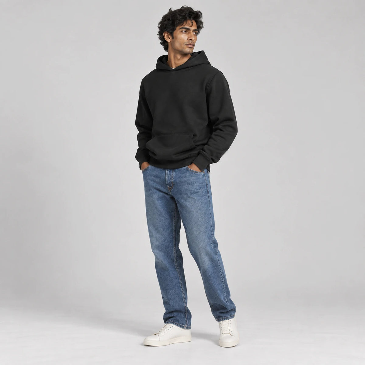 MOMANI Essential Hoodie in Black, worn by a model, three-quarter view