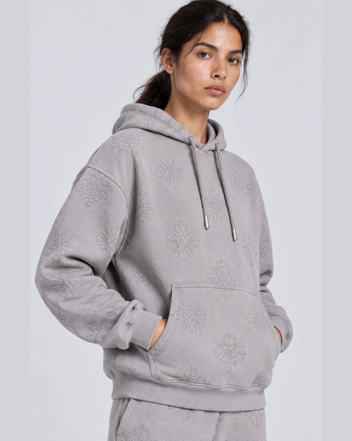 MOMANI Emblem Jacquard Hoodie in Grey, worn by a model, close detail
