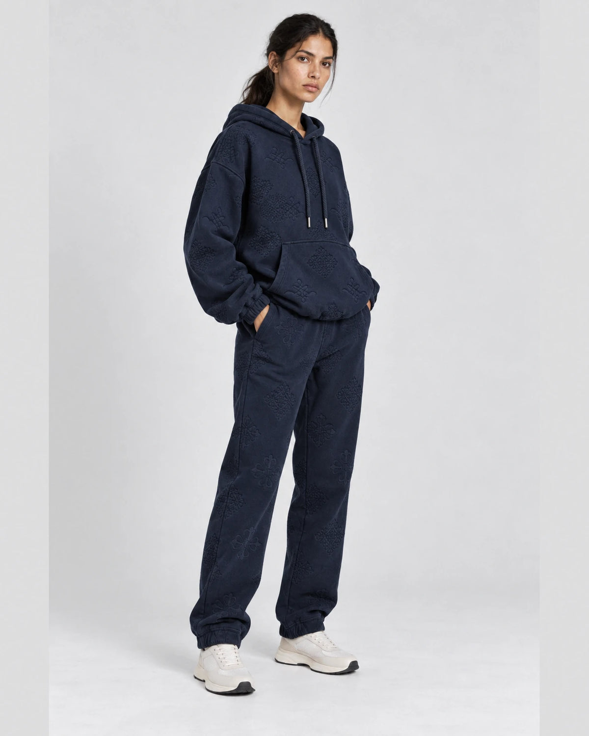 MOMANI Emblem Jacquard Hoodie in Navy, worn by a model, three-quarter view