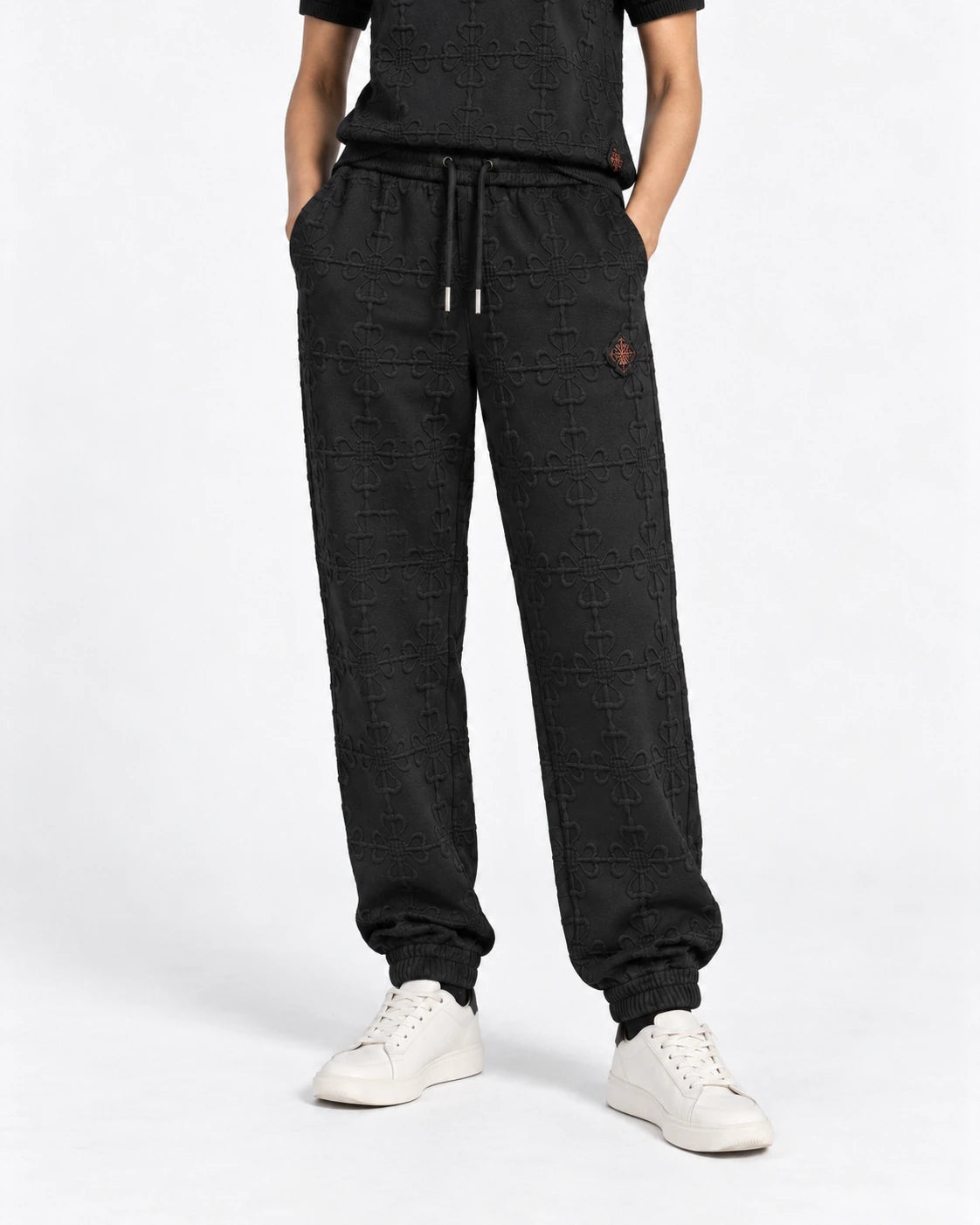 MOMANI Emblem Terry Trousers in Black, worn by a model, close detail