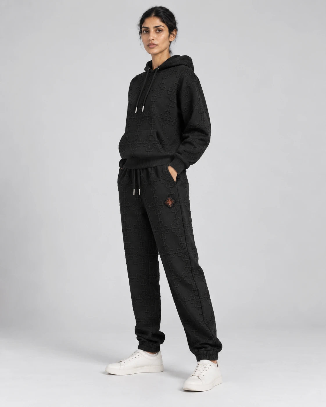 MOMANI Emblem Terry Trousers in Black, worn by a model, three-quarter view