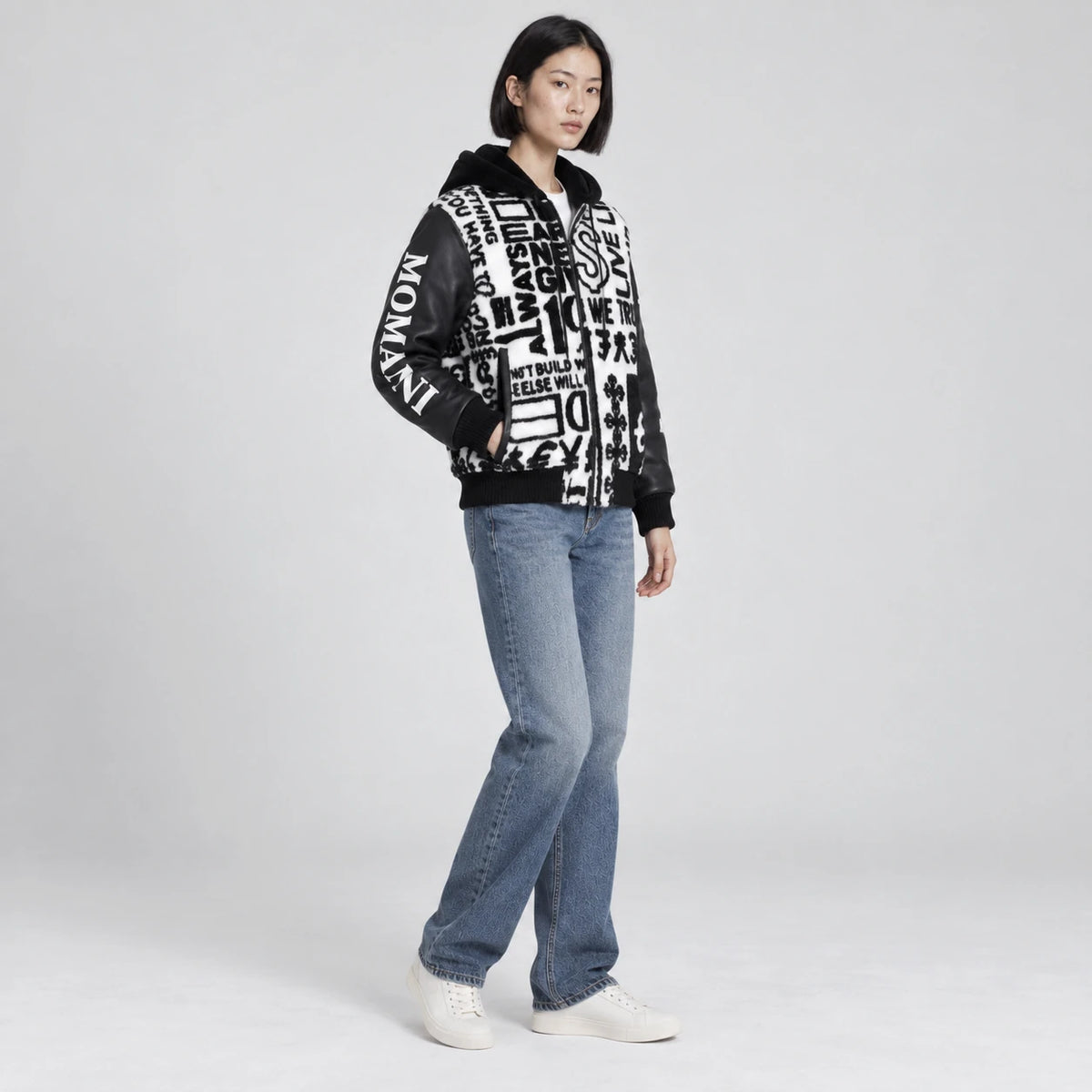 MOMANI Typographic Hooded Coat in Black, worn by a model, three-quarter view
